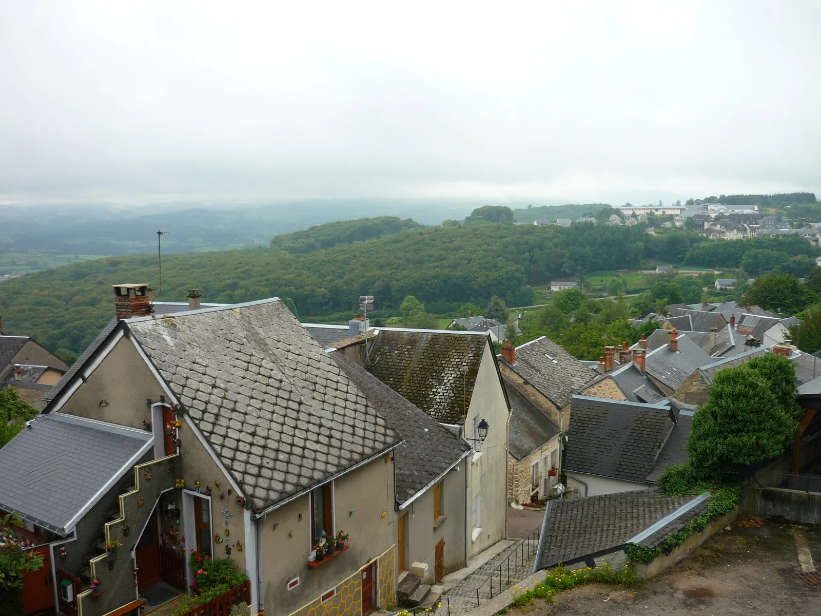 Les toits d’ardoise de la ville haute de Château-Chinon, avec la forêt du Morvan et la brume en arrière-plan
