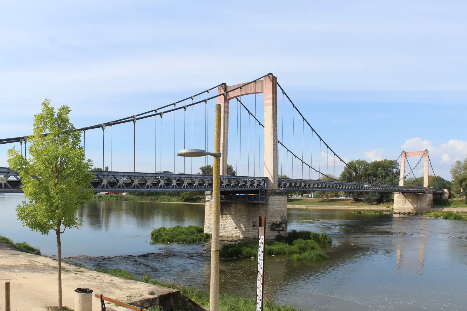 Le pont suspendu de Cosne-Cours-sur-Loire au-dessus de la Loire, vu depuis le quai par une journée ensoleillée